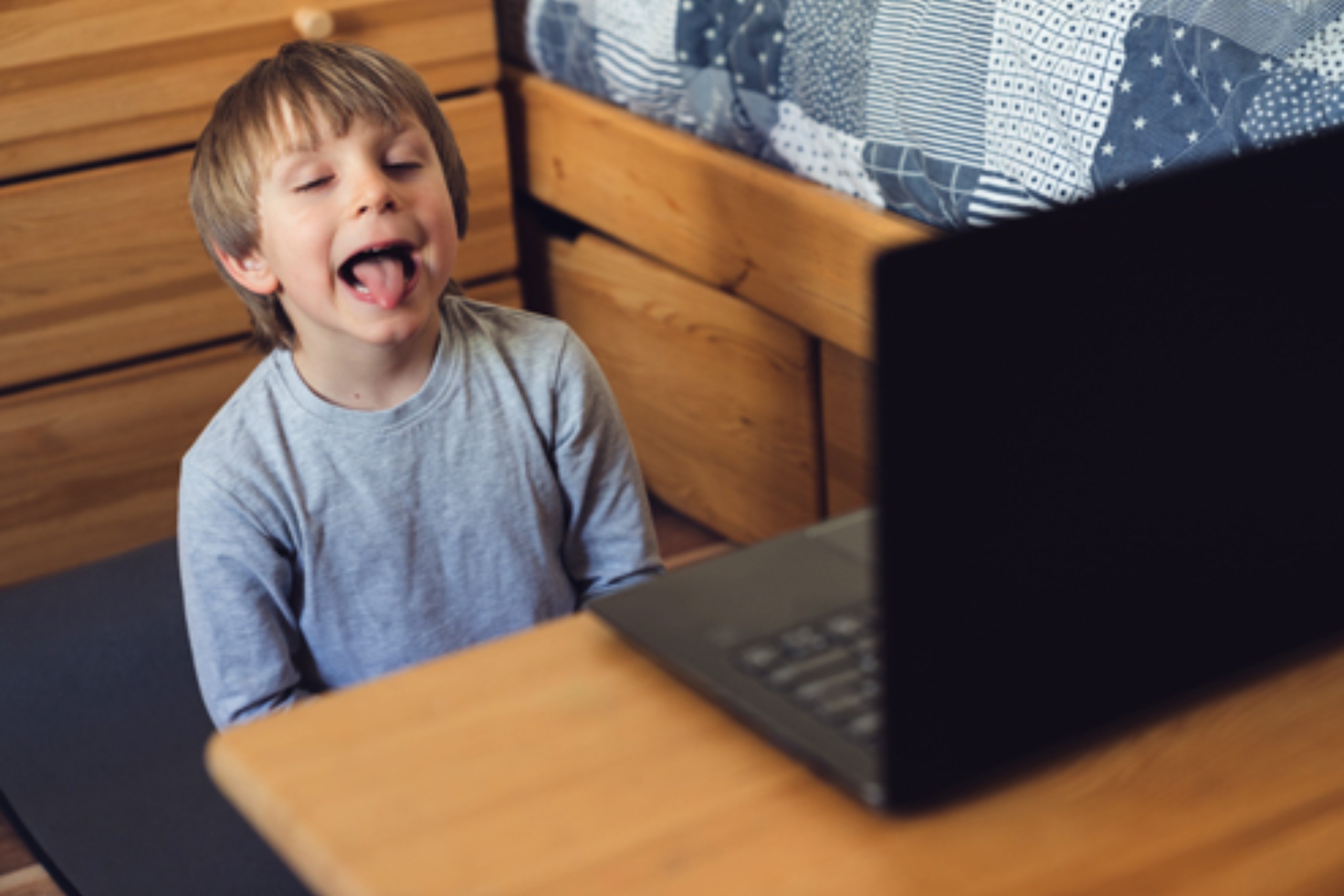 a cheerful child engaging in teletherapy - online speech therapy